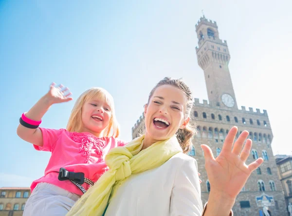 Lachende moeder en dochter in de buurt van Palazzo Vecchio handwaving — Stockfoto