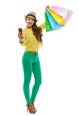 Kadın şapka ve parlak kıyafetleri ile alışveriş torbaları selfie alarak