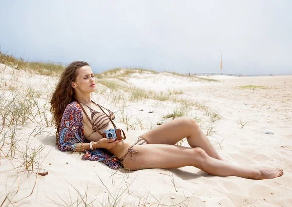 Uvolněný český žena s retro fotoaparátu na pláži — Stock fotografie