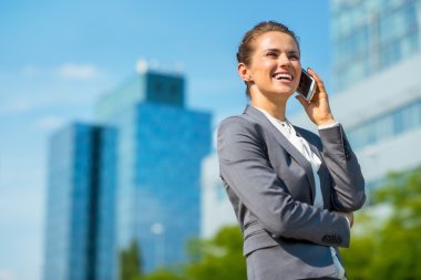Gülümseyen iş kadın cep telefonu konuşurken ofis semtinde