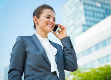 Gülümseyen iş kadın cep telefonu konuşurken ofis semtinde
