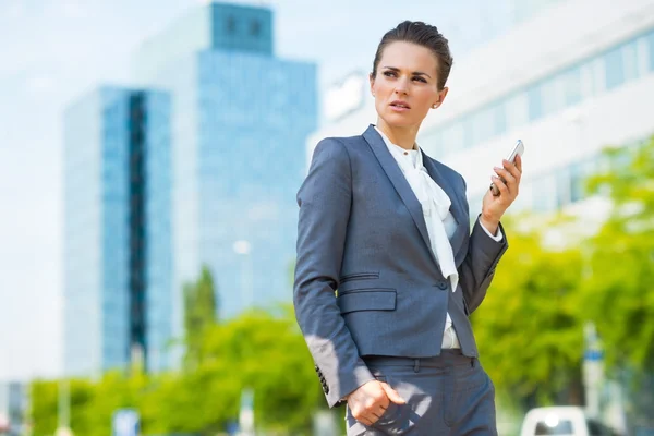 Mujer de negocios con teléfono celular en el moderno distrito de oficinas —  Fotos de Stock