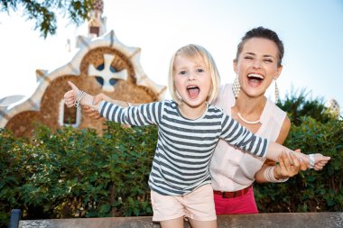 Gülümseyen anne ve çocuk eğleniyor Park Guell zaman