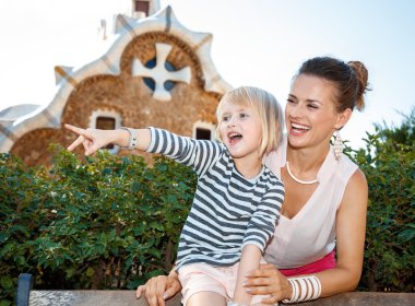 Anne ve çocuk Park Guell içinde bir şey üzerinde işaret gülümseyen