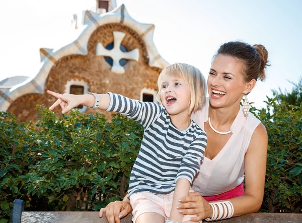 Glimlachen van moeder en kind wijzen op iets in Park Guell — Stockfoto