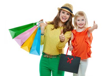 Mutlu anne ve kızı ile alışveriş torbaları başparmak gösterilmesini