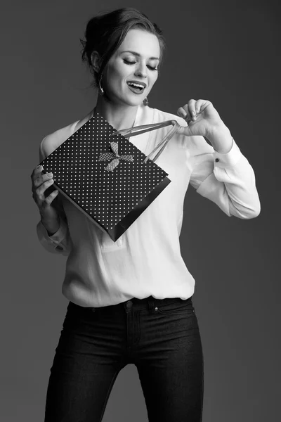 Элегантная женщина с сумкой для покупок на сером фоне — стоковое фото