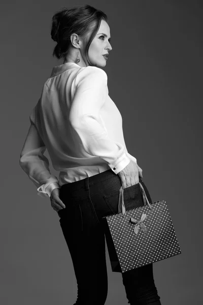 Alışveriş çantası gri arka planı poz ile modern kadın — Stok fotoğraf