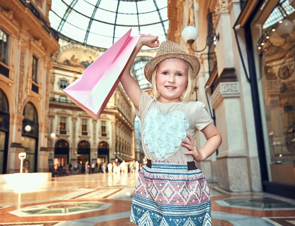 快乐时尚女孩提着购物袋在拱廊的肖像 — 图库照片