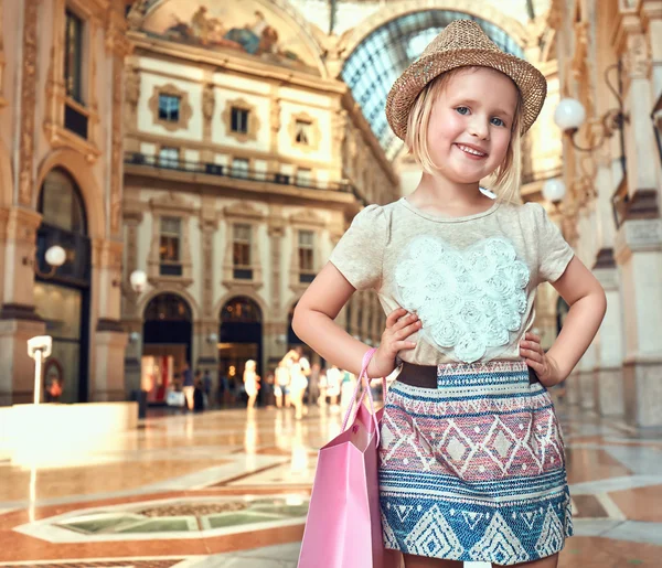 Portræt af glad mode pige med indkøbspose i Galleria - Stock-foto