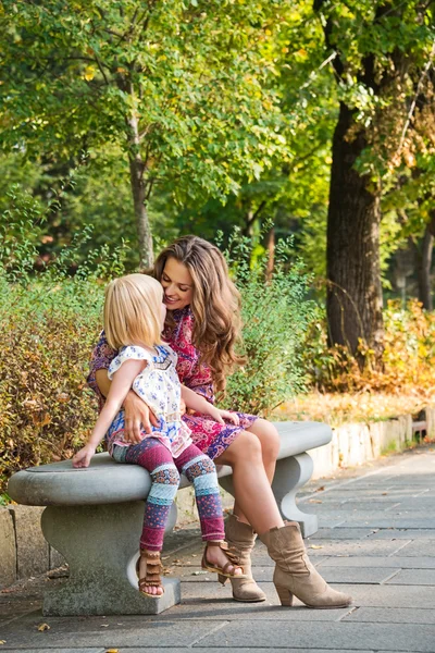 Mutlu anne ve kızı parkta bankta oturmuş. — Stok fotoğraf