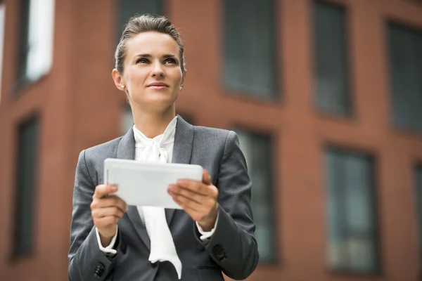 Mujer de negocios moderna con tableta PC contra edificio de oficinas — Foto de Stock