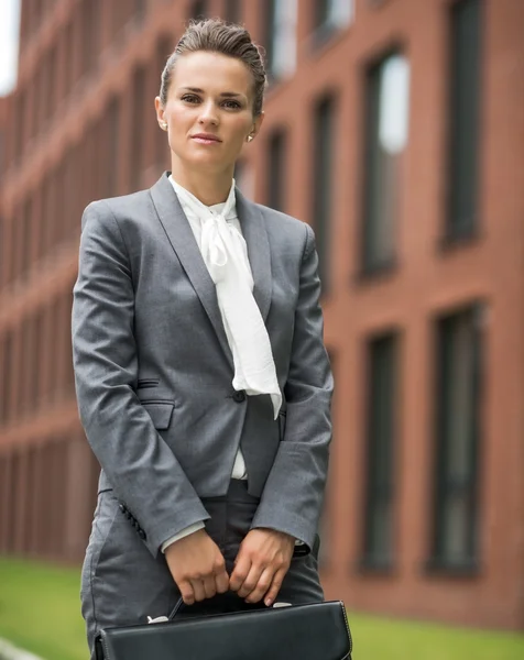 Portrait de femme d'affaires avec mallette près de l'immeuble de bureaux — Photo