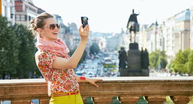 Prag'da dijital fotoğraf makinesiyle fotoğraf çeken gülümseyen kadın