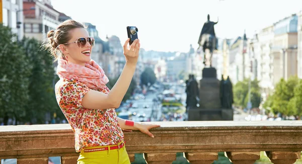 Femme souriante prenant des photos avec un appareil photo numérique à Prague — Photo