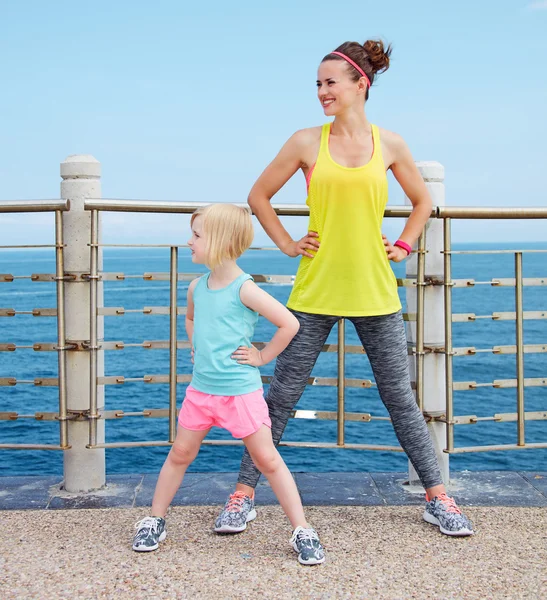 Matka a dítě v fitness oblečení strečink na nábřeží — Stock fotografie