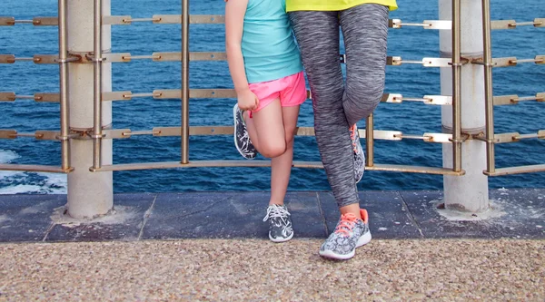 Happy mother and child in fitness outfit standing on embankment — Stock Photo, Image