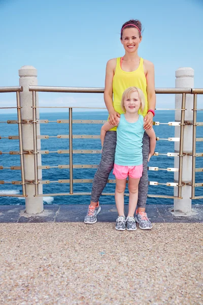 Matka a dítě ve fitness oblečení stojí na nábřeží — Stock fotografie