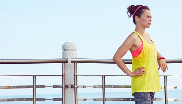 Fitness vrouw op zoek naar afstand en luisteren naar de muziek — Stockfoto