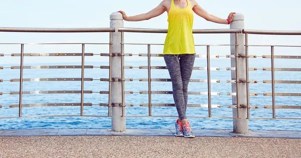 Žena v fitness oblečení relaxaci po cvičení na nábřeží — Stock fotografie