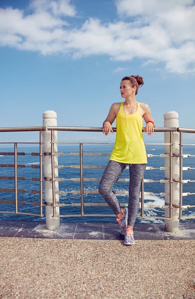 Entspannte Fitness-Frau blickt an Böschung in die Ferne — Stockfoto