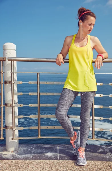 Healthy woman in fitness outfit looking aside at embankment — Stock Photo, Image