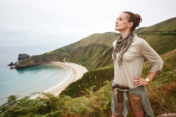 Zrelaksowany aktywny Hiker kobieta przed widokiem na ocean krajobraz — Zdjęcie stockowe
