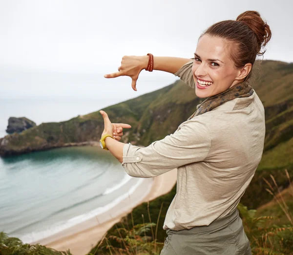 Woman hiker framing with hands in front of ocean view landscape — Stock Photo, Image