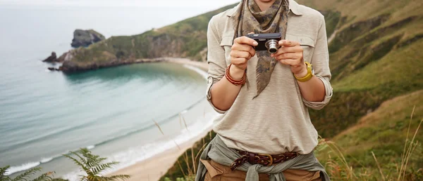 Woman hiker viewing photos in front of ocean view landscape — Stock Photo, Image