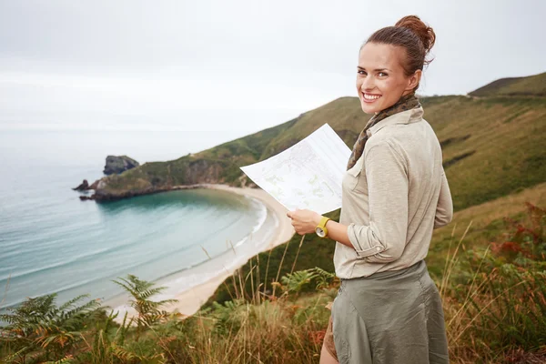 Mulher feliz caminhante com mapa na frente da paisagem vista mar — Fotografia de Stock