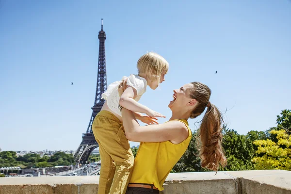 Lykkelig mor og barn har det sjovt tid mod Eiffeltårnet - Stock-foto