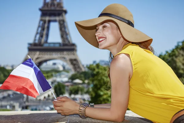 Gelukkige vrouw met Franse vlag in de voorkant van de Eiffel toren in Parijs — Stockfoto