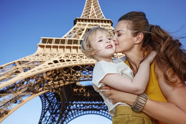 Gelukkig moeder en kind toeristen kussen tegen Eiffeltoren — Stockfoto