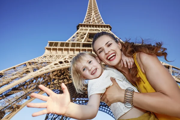 Feliz madre e hija saludando con la mano contra la torre Eiffel —  Fotos de Stock