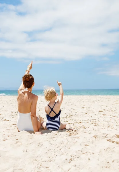 Von hinten gesehen Mutter und Kind zeigen auf Sandstrand — Stockfoto