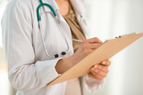 Primer plano sobre la escritura del médico femenino en portapapeles —  Fotos de Stock