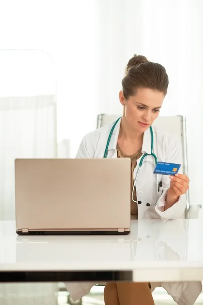 Médico femenino con compras con tarjeta de crédito en línea en la oficina — Foto de Stock