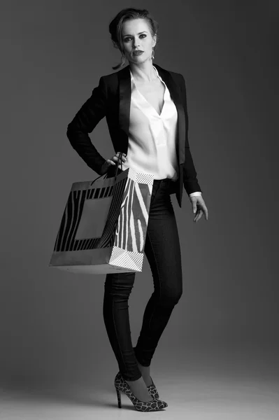 灰色の背景に対して大きめの買い物袋を持つエレガントな女性 — ストック写真