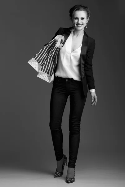灰色の背景に対して大きな買い物袋を笑顔の女性 — ストック写真