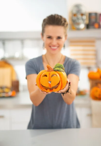 Primer plano de la mujer que muestra la calabaza de halloween de cerámica en la cocina — Foto de Stock