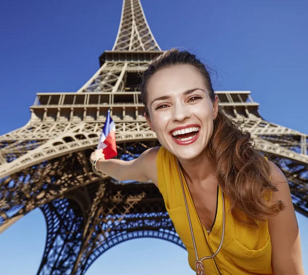 Porträtt av lycklig kvinna stigande flagga mot Eiffeltornet, Paris — Stockfoto