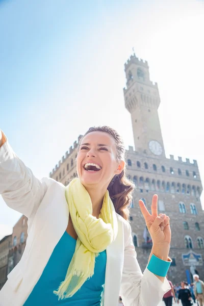 Žena ukazuje vítězství a pořizování selfie poblíž Palazzo Vecchio — Stock fotografie