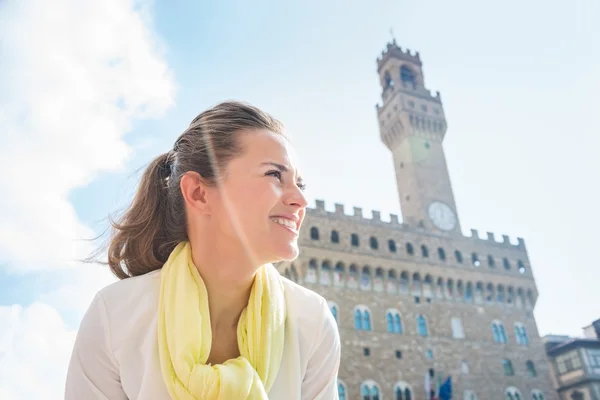 Donna sorridente in piedi vicino a Palazzo Vecchio e guardando da parte — Foto Stock