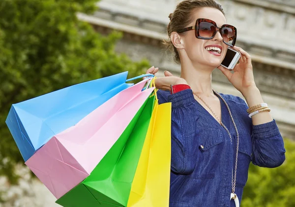 fashion-monger with shopping bags using smartphone, Paris