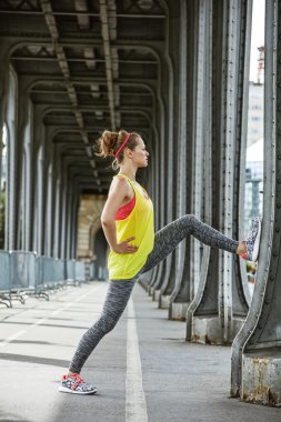 Paris Pont de Bir-Hakeim köprüde germe kadın koşucu