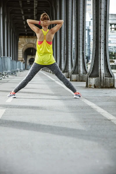 Vrouw jogger uitrekken op Pont de Bir-Hakeim brug in Parijs — Stockfoto