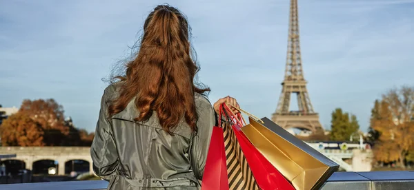 Elegante vrouw met boodschappentassen op zoek op Eiffeltoren, Parijs — Stockfoto