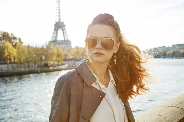 Молодая женщина на набережной в Париже смотрит вдаль — стоковое фото
