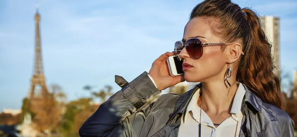 Unga trendiga kvinnan talar på smartphone nära Eiffeltornet — Stockfoto