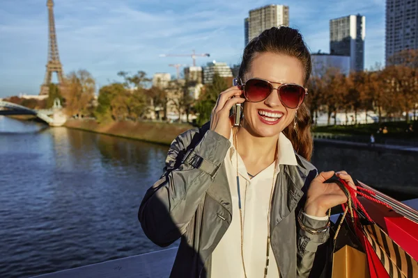 Vrouw met boodschappentassen praten op mobiele telefoon in de buurt van Eiffel tower — Stockfoto